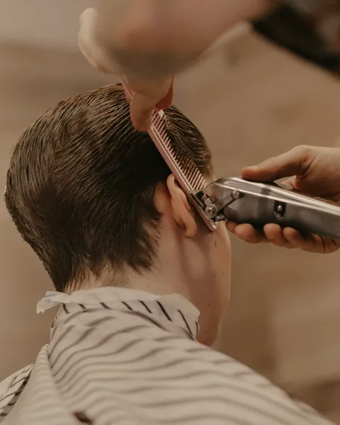 Side-parted classic taper being cut over the comb (example photo)