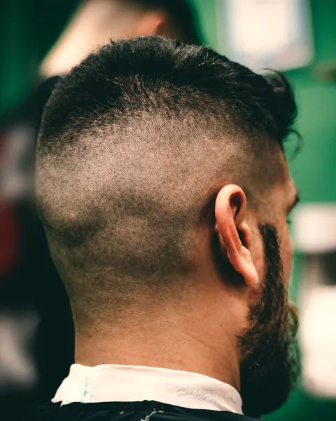 Rear view of a skin fade, bare at the sides and blended into short hair on top (example photo)