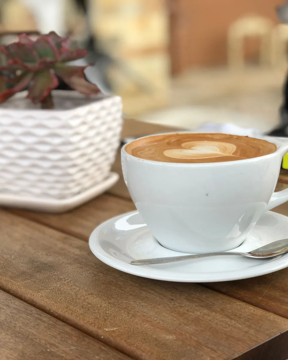 Sample photo: a cappuccino on a saucer, on a wooden table