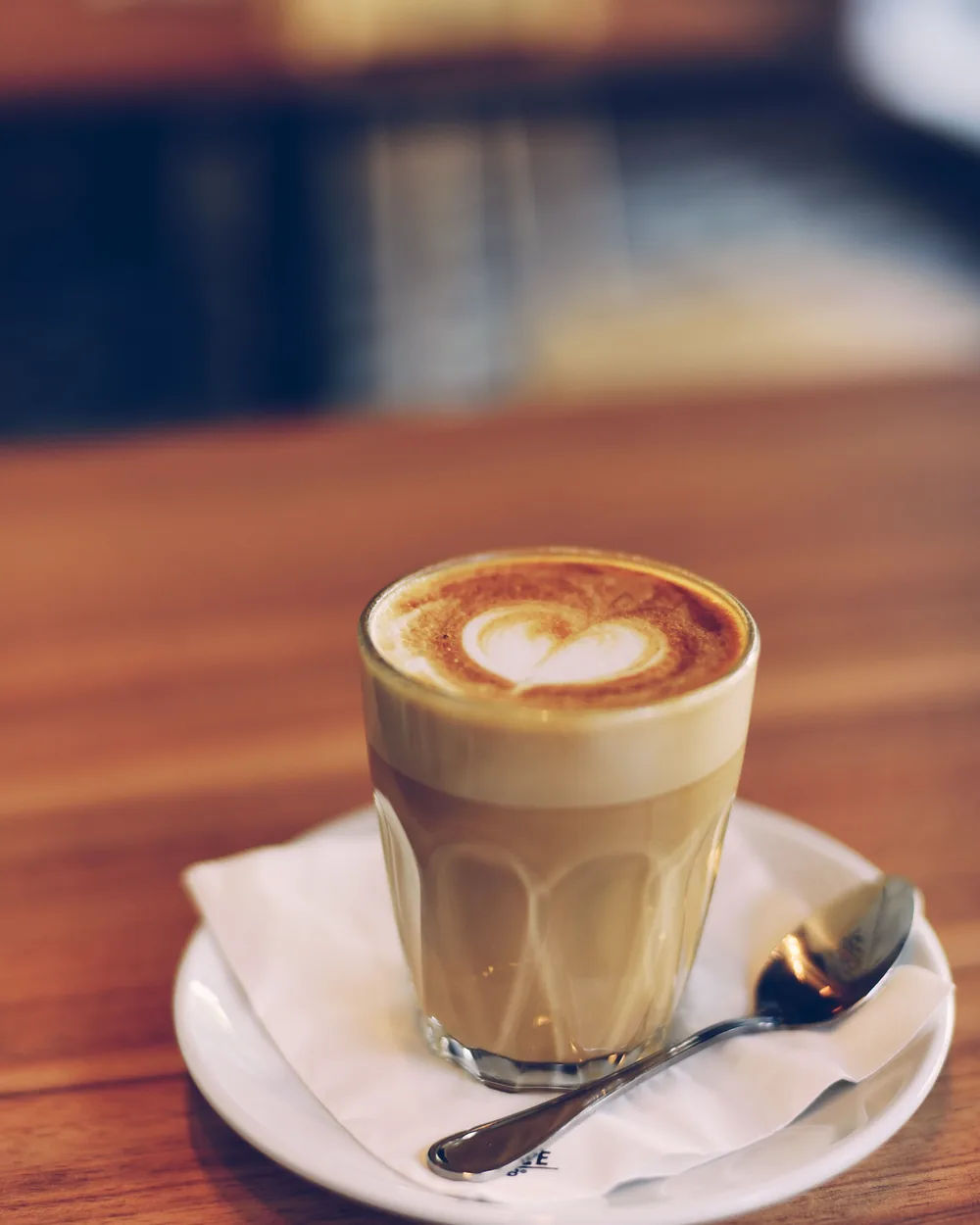 Sample photo: a latte in a tall glass on a saucer