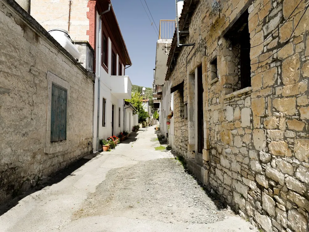 Quiet village lane lined with old stone houses and potted flowers