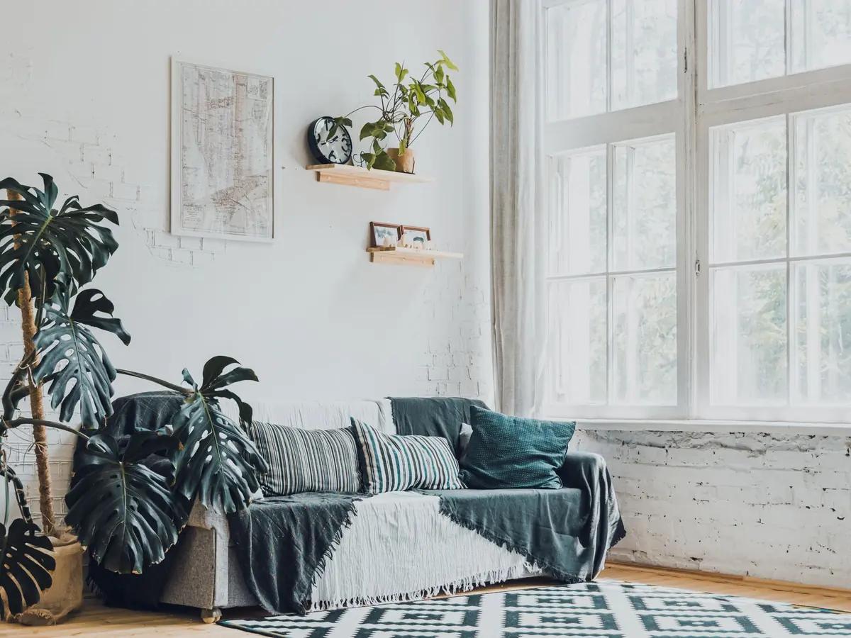 A bright living room with white walls and a linen sofa.